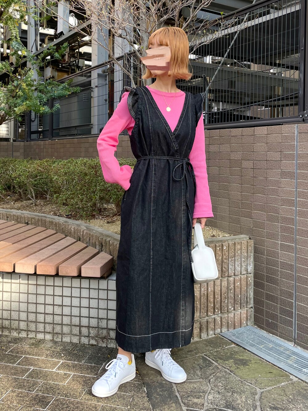 ブラック系のワンピース、ピンク系のTシャツ/カットソー、ホワイト系のハンドバッグを着用したレディースの春コーディネートの2枚目の写真