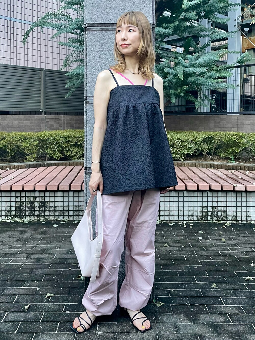 ブラック系のキャミソール、ピンク系のカーゴパンツ、ピンク系のキャミソールを着用したレディースの夏コーディネートの2枚目の写真