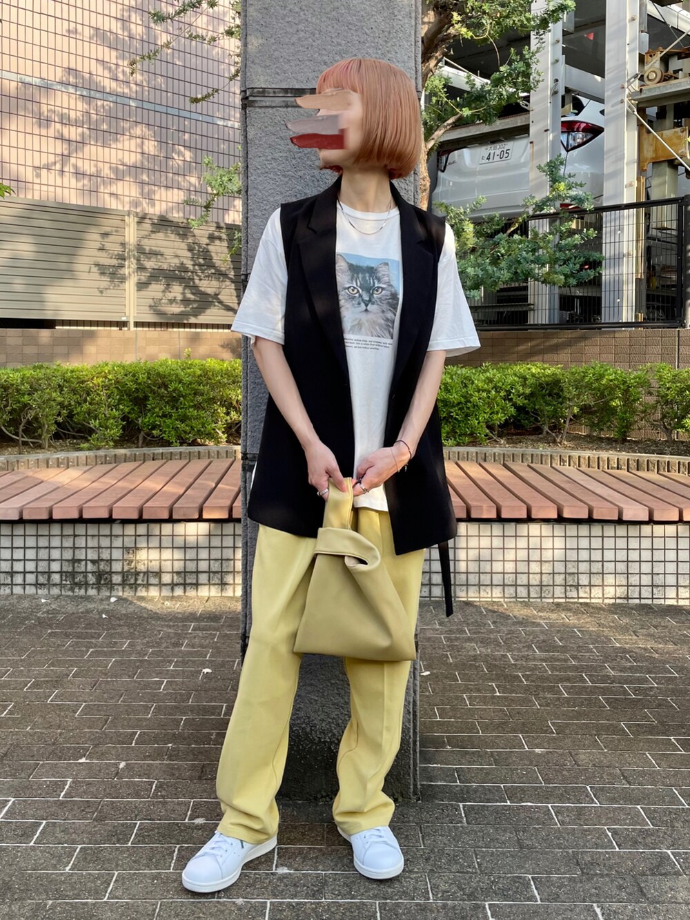 ホワイト系のTシャツ/カットソー、ブラック系のベスト、グリーン系のハンドバッグを着用したレディースの春コーディネートの2枚目の写真