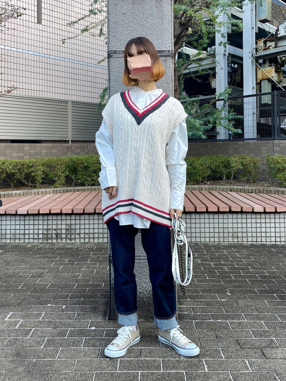 ベージュ系のスニーカー、ブルー系のデニムパンツ、ブラック系のライダースジャケットを着用したレディースの秋コーディネートの2枚目の写真