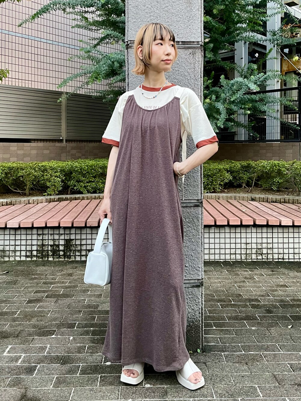 ピンク系のベスト、ブラウン系のワンピース、ブラウン系のTシャツ/カットソーを着用したレディースの夏コーディネートの2枚目の写真