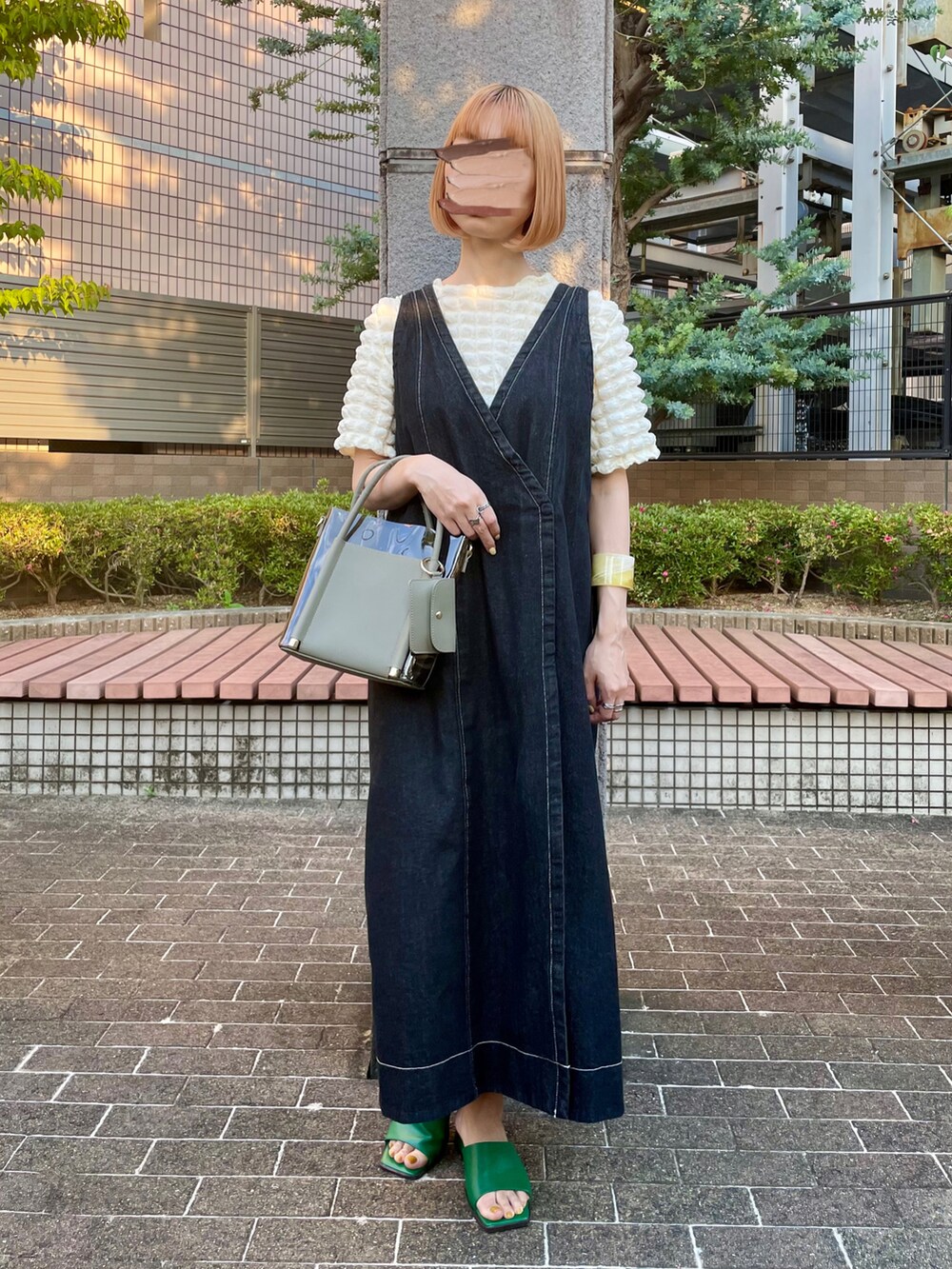 ブラック系のワンピース、ホワイト系のシャツ/ブラウス、グリーン系のショルダーバッグを着用したレディースの春コーディネートの2枚目の写真