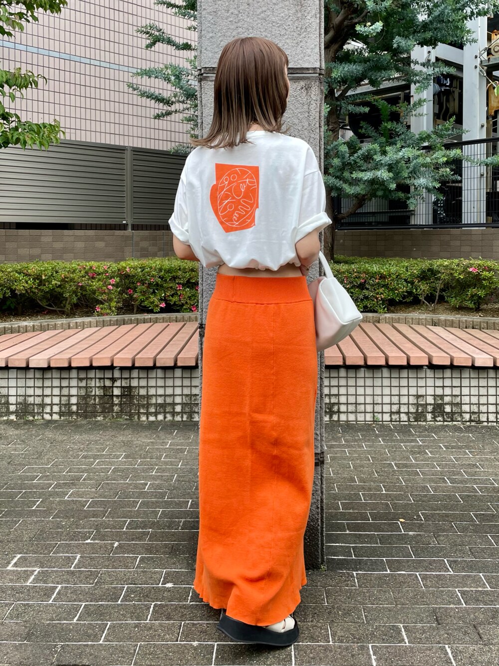 ホワイト系のTシャツ/カットソー、オレンジ系のスカート、ホワイト系のサンダルを着用したレディースの夏コーディネートの2枚目の写真
