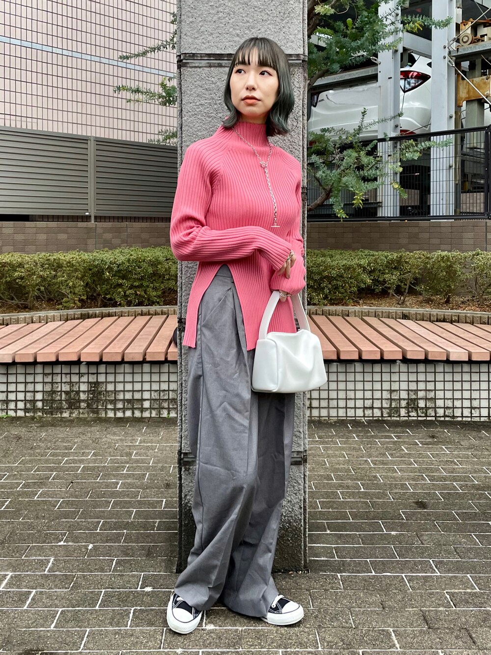 ブラック系のムートンコート、ピンク系のニット/セーター、グレー系のスラックスを着用したレディースの冬コーディネートの3枚目の写真