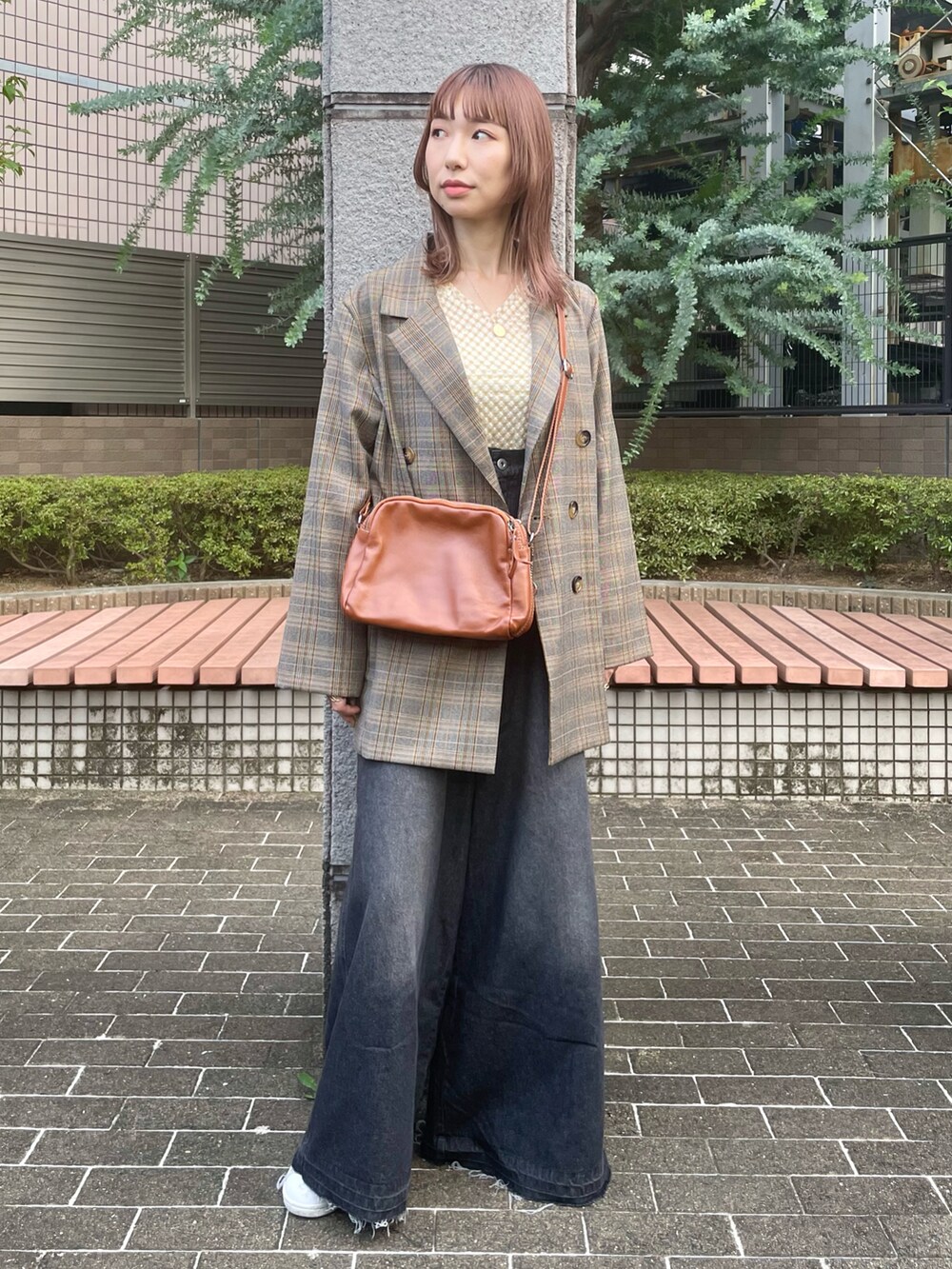 ホワイト系のTシャツ/カットソー、ベージュ系のテーラードジャケット、ブラック系のサロペット/オーバーオールを着用したレディースの秋コーディネートの2枚目の写真