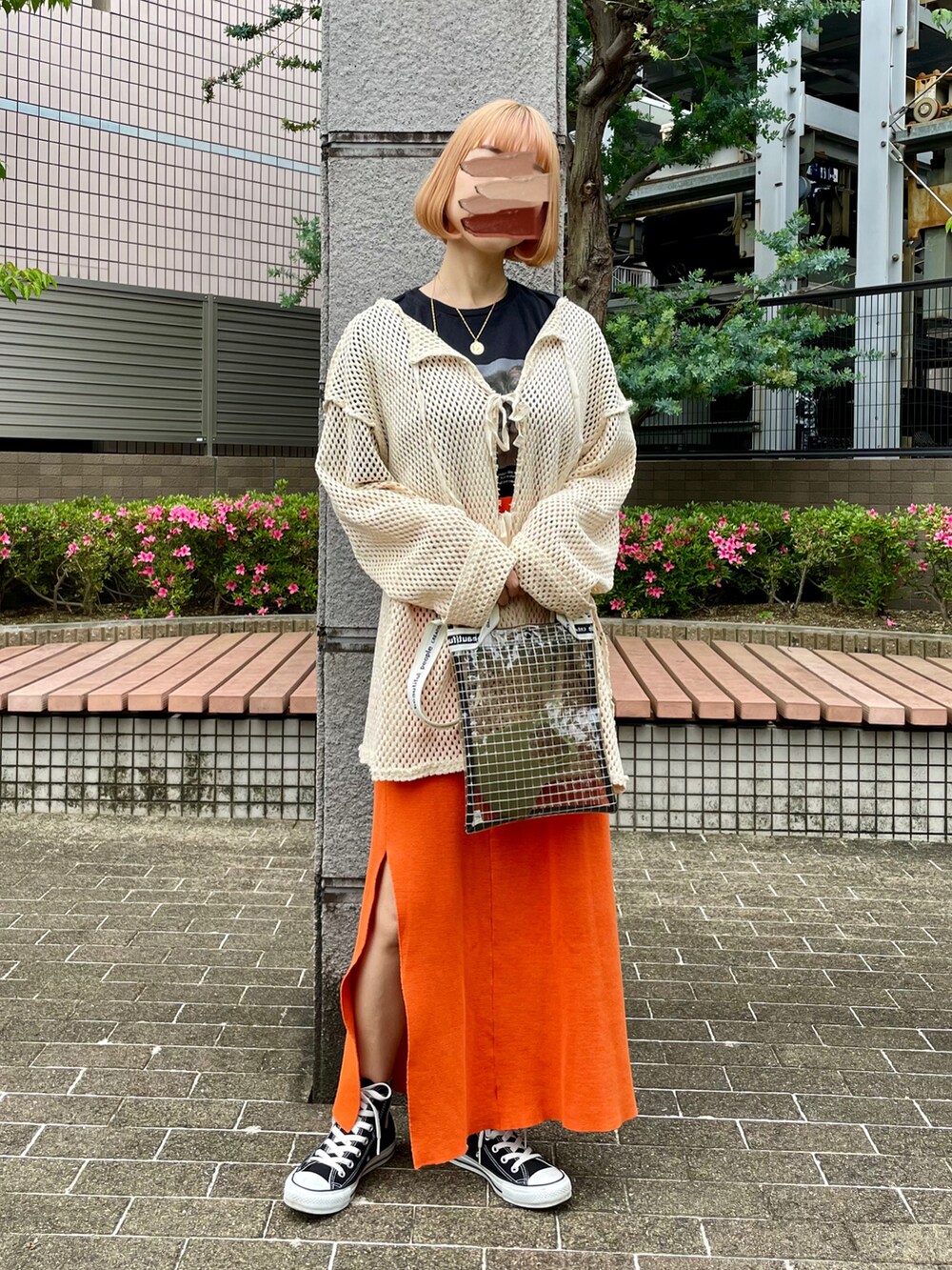 オレンジ系のスカート、ブラック系のTシャツ/カットソー、ベージュ系のTシャツ/カットソーを着用したレディースの春コーディネートの2枚目の写真