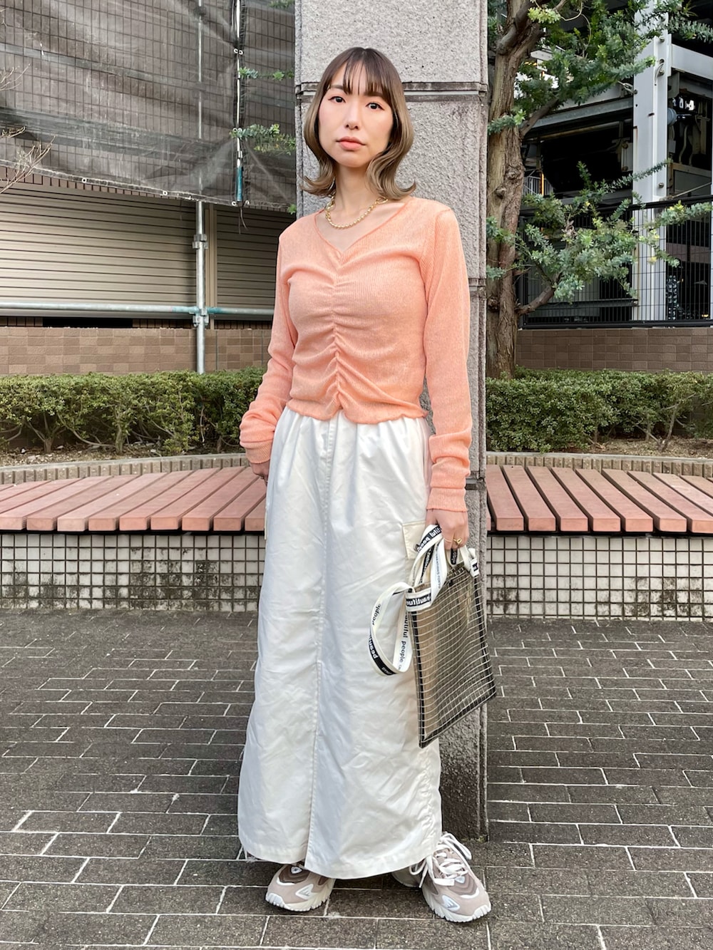 ホワイト系のシャツ/ブラウス、オレンジ系のTシャツ/カットソー、ホワイト系のスカートを着用したレディースの春コーディネートの2枚目の写真