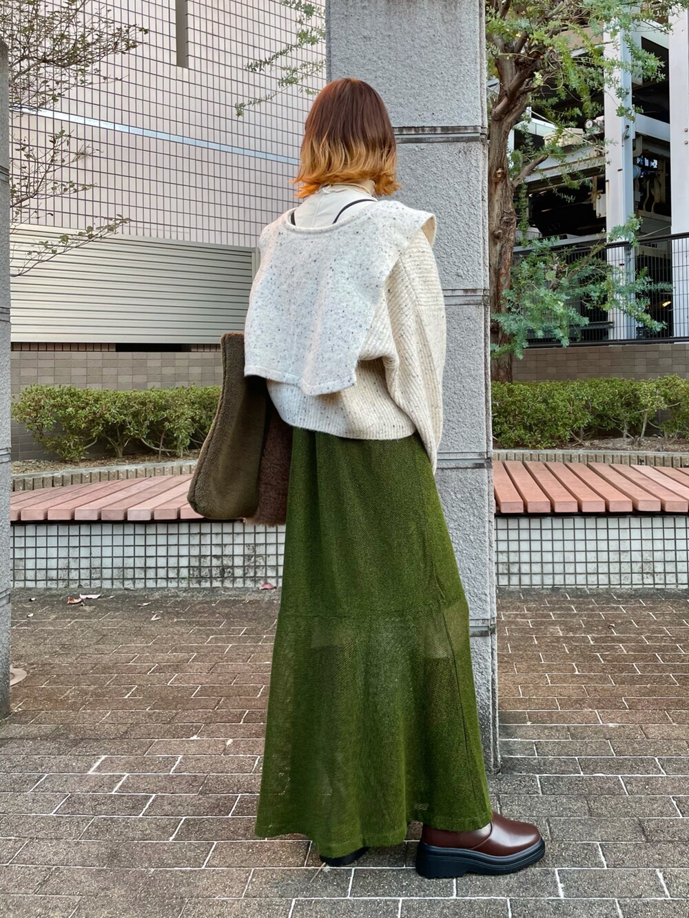 ブラウン系のトートバッグ、グリーン系のワンピース、ホワイト系のTシャツ/カットソーを着用したレディースの秋コーディネートの2枚目の写真