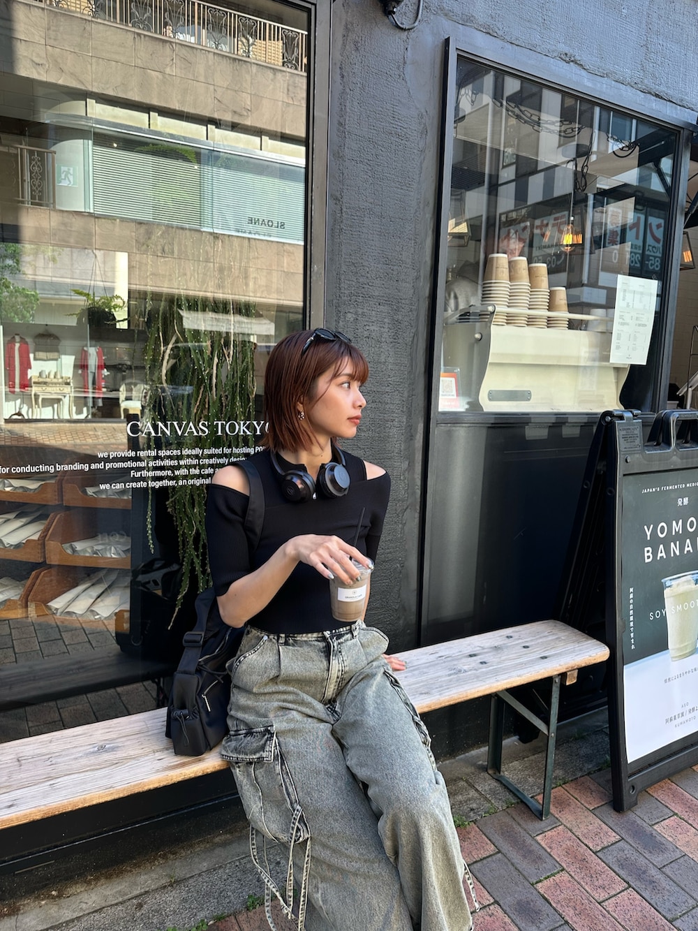 ブラック系のニット/セーター、ブラック系のデニムパンツ、ブラック系のショルダーバッグを着用したレディースの春コーディネートの3枚目の写真