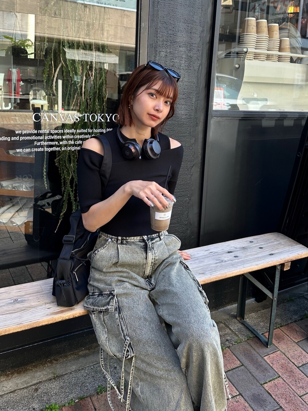 ブラック系のニット/セーター、ブラック系のデニムパンツ、ブラック系のショルダーバッグを着用したレディースの春コーディネートの4枚目の写真