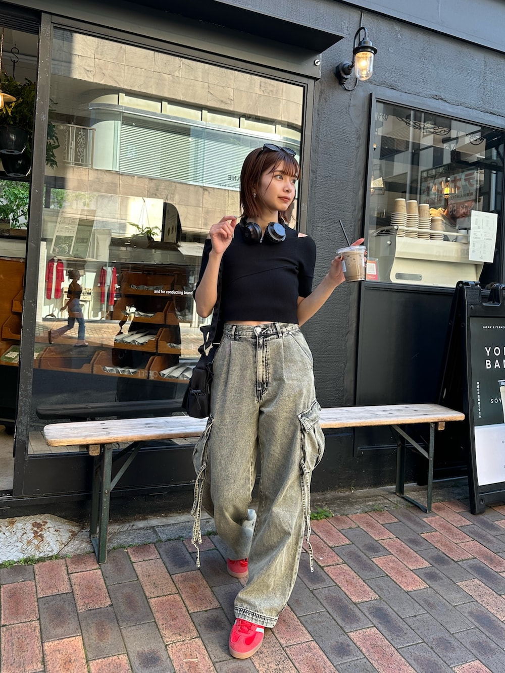 ブラック系のニット/セーター、ブラック系のデニムパンツ、ブラック系のショルダーバッグを着用したレディースの春コーディネートの2枚目の写真