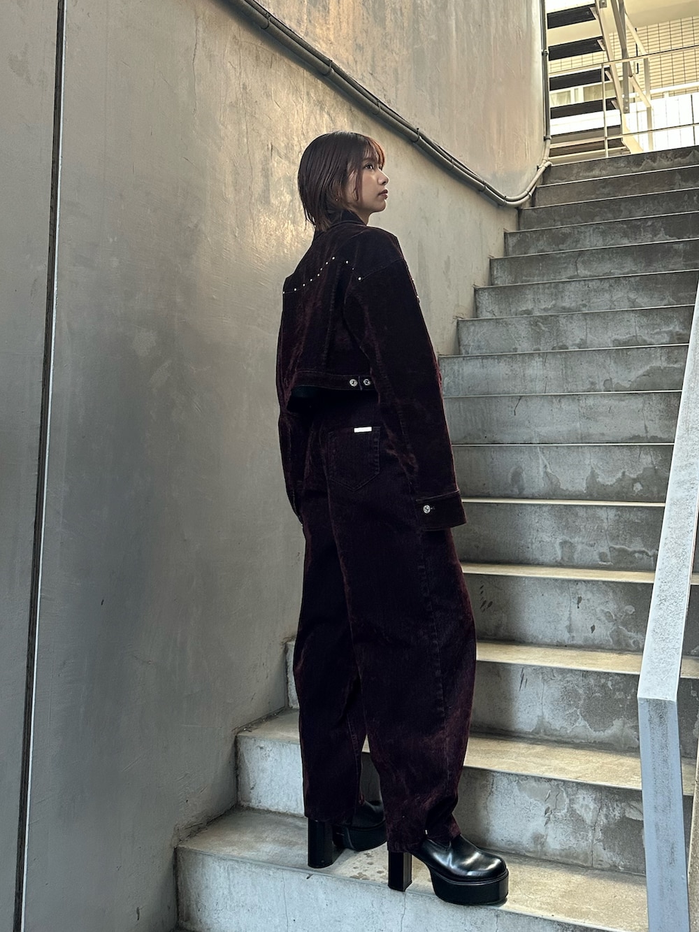レッド系のデニムジャケット、レッド系のデニムパンツ、グリーン系のタンクトップを着用したレディースの夏コーディネートの3枚目の写真