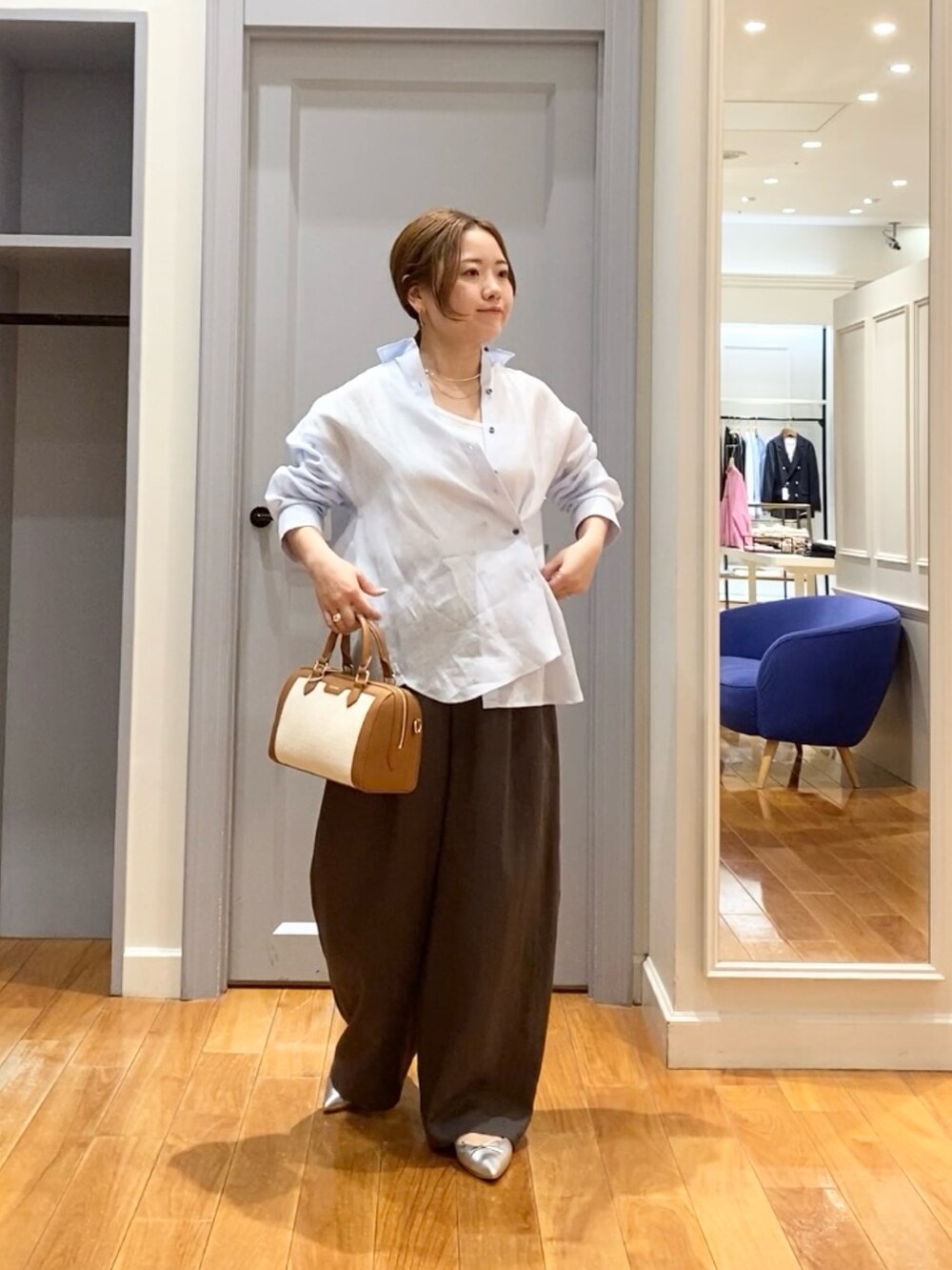 ブルー系のシャツ/ブラウス、ブラウン系のボストンバッグ、グリーン系のその他パンツを着用したレディースの春コーディネートの5枚目の写真