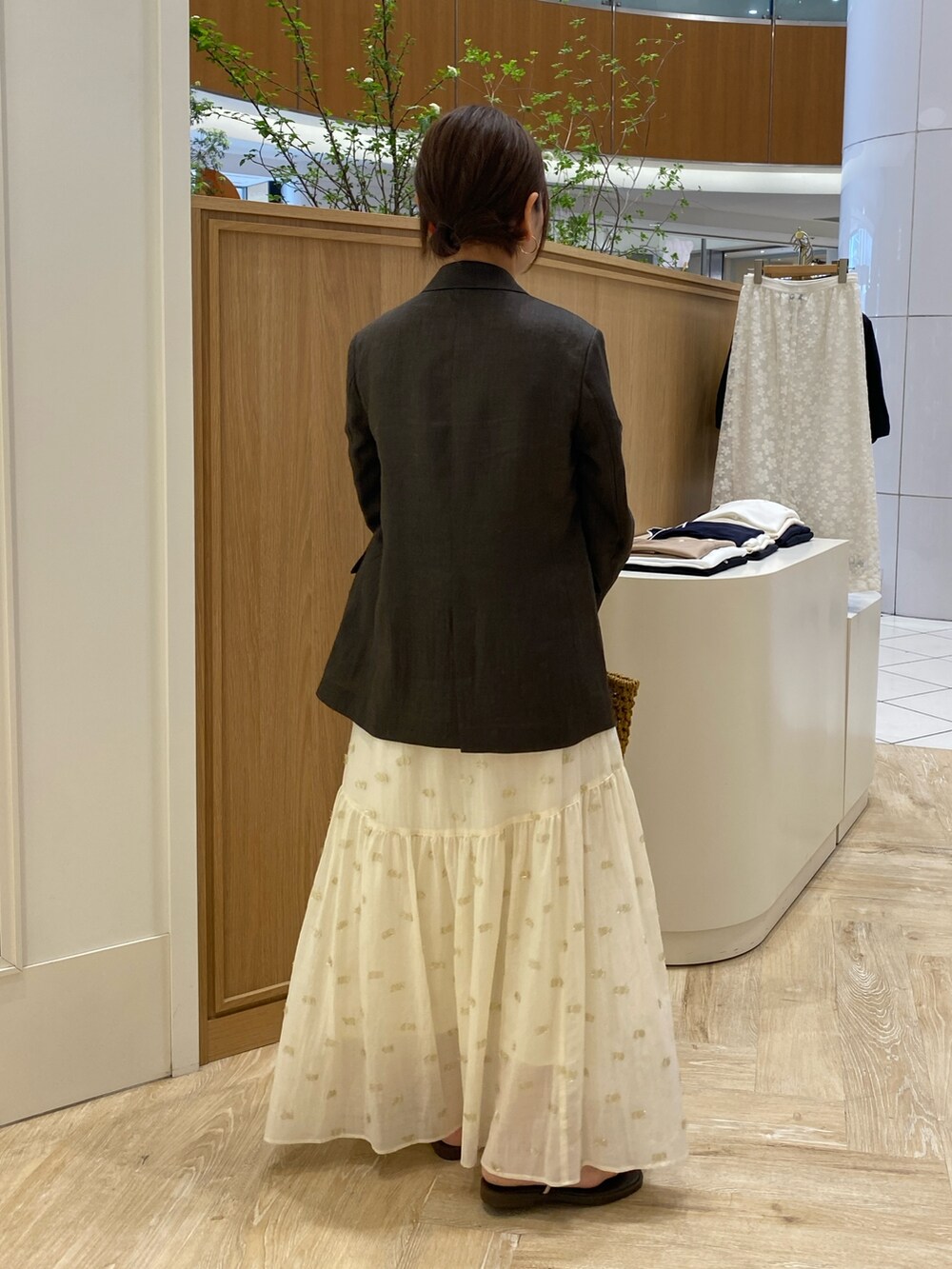 ブラウン系のテーラードジャケット、ベージュ系のかごバッグ、ブラウン系のサンダルを着用したレディースの春コーディネートの5枚目の写真