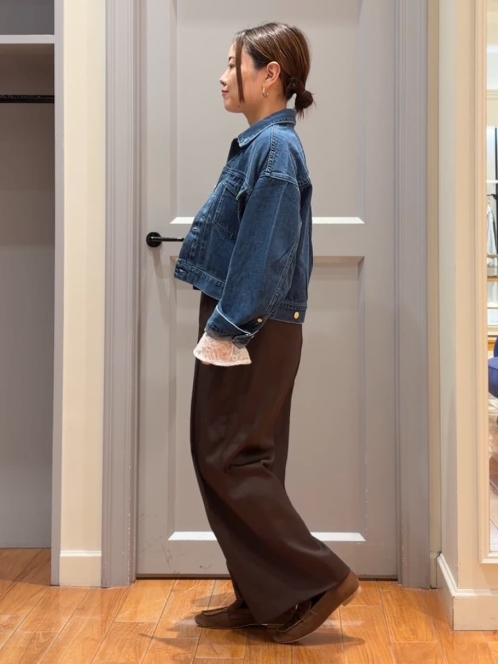 ブルー系のデニムジャケット、ブラウン系のその他パンツ、ホワイト系のシャツ/ブラウスを着用したレディースの秋コーディネートの2枚目の写真