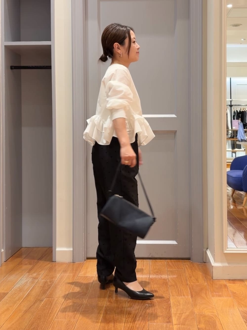ブラック系のその他パンツ、ホワイト系のシャツ/ブラウス、ブルー系のショルダーバッグを着用したレディースの夏コーディネートの2枚目の写真