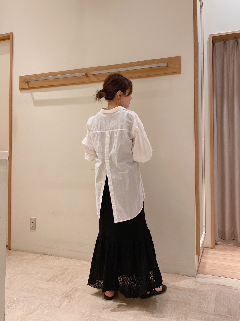 ホワイト系のシャツ/ブラウス、ブラック系のスカートを着用したレディースの夏コーディネートの2枚目の写真