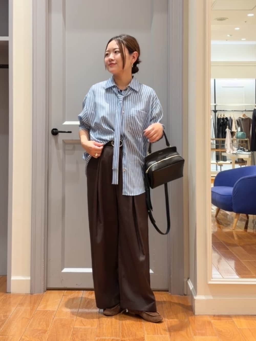 ブルー系のシャツ/ブラウス、ブラウン系のベスト、ブラウン系のその他パンツを着用したレディースの秋コーディネートの5枚目の写真