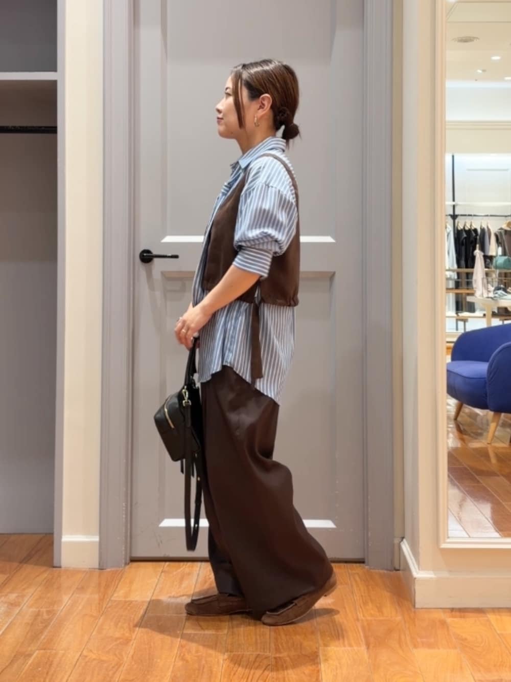 ブルー系のシャツ/ブラウス、ブラウン系のベスト、ブラウン系のその他パンツを着用したレディースの秋コーディネートの2枚目の写真