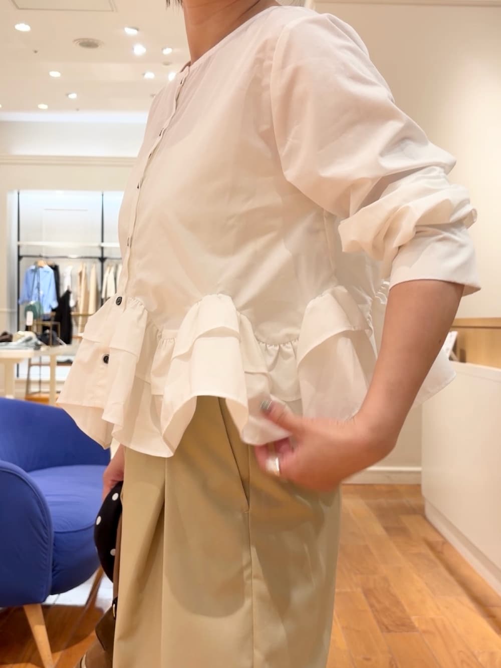 ベージュ系のチノパンツ、ホワイト系のシャツ/ブラウス、イエロー系のショルダーバッグを着用したレディースの夏コーディネートの3枚目の写真