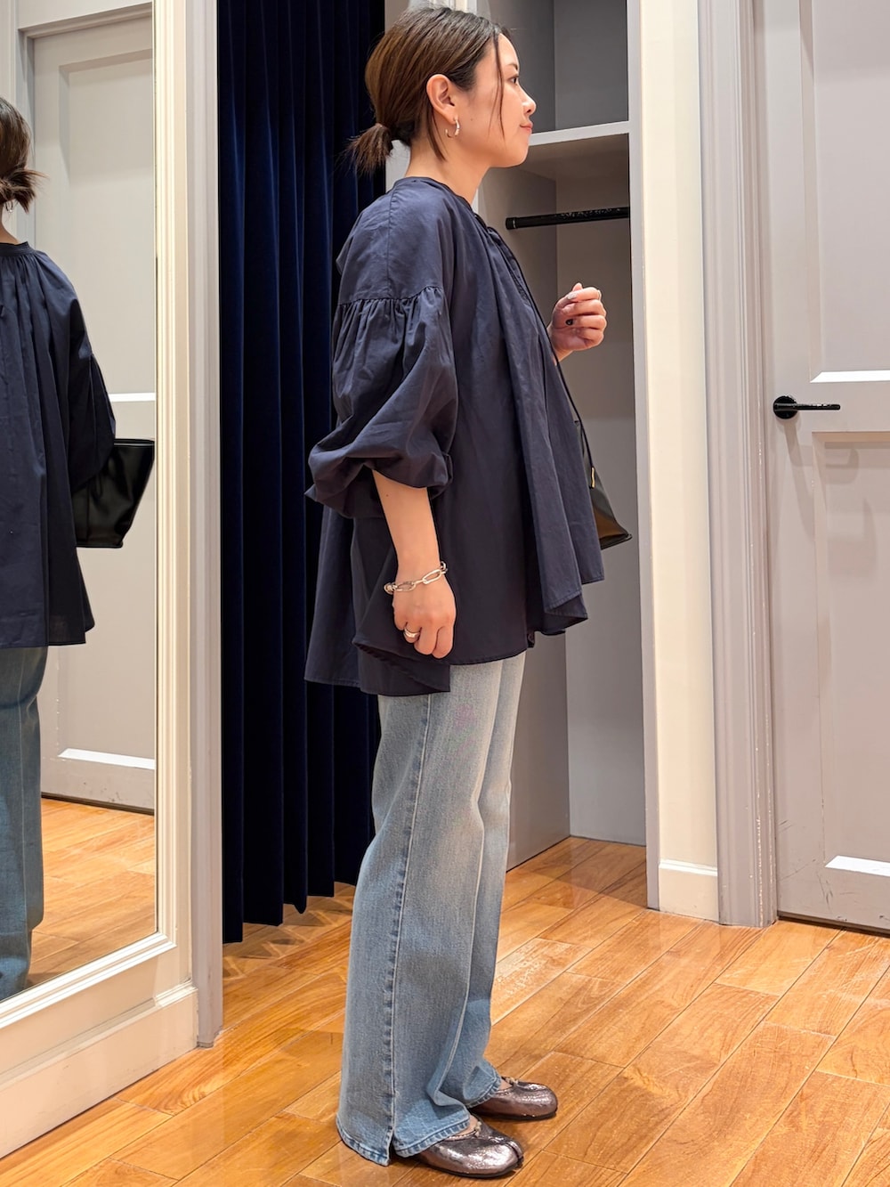 ブルー系のシャツ/ブラウス、ホワイト系のタンクトップ、ブルー系のデニムパンツを着用したレディースの秋コーディネートの5枚目の写真