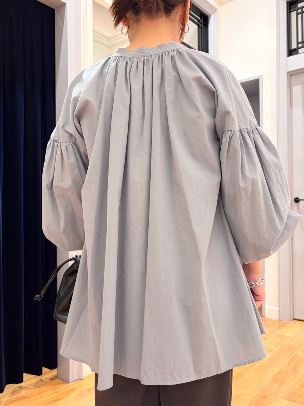 ブラック系のショルダーバッグ、グレー系のその他パンツ、ホワイト系のタンクトップを着用したレディースの秋コーディネートの3枚目の写真