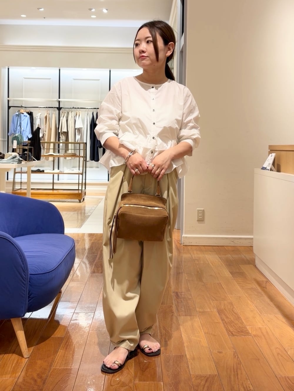 ベージュ系のチノパンツ、ホワイト系のシャツ/ブラウス、イエロー系のショルダーバッグを着用したレディースの夏コーディネートの4枚目の写真