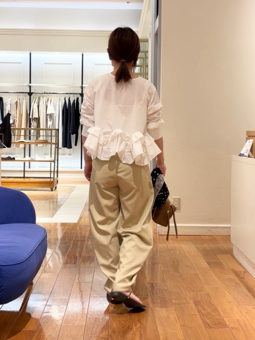 ベージュ系のチノパンツ、ホワイト系のシャツ/ブラウス、イエロー系のショルダーバッグを着用したレディースの夏コーディネートの2枚目の写真
