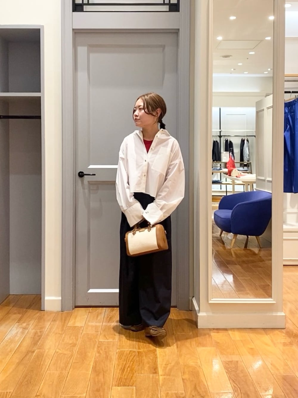 ホワイト系のシャツ/ブラウス、ブルー系のその他パンツ、ブラウン系のボストンバッグを着用したレディースの春コーディネートの4枚目の写真