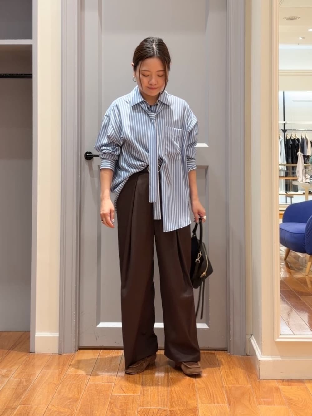 ブルー系のシャツ/ブラウス、ブラウン系のベスト、ブラウン系のその他パンツを着用したレディースの秋コーディネートの7枚目の写真