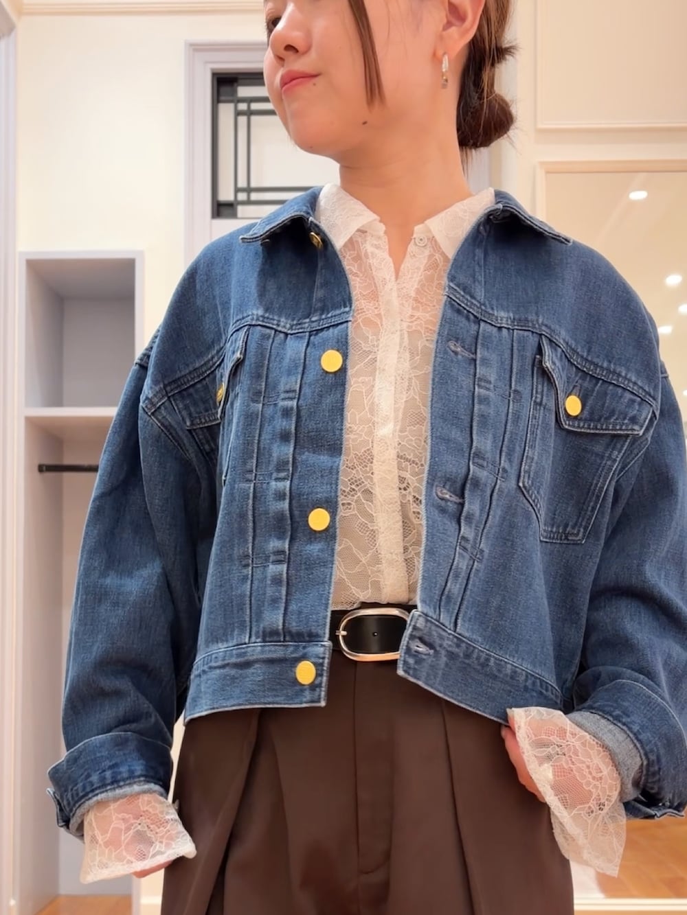 ブルー系のデニムジャケット、ブラウン系のその他パンツ、ホワイト系のシャツ/ブラウスを着用したレディースの秋コーディネートの4枚目の写真