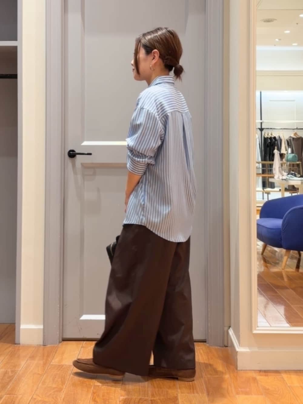 ブルー系のシャツ/ブラウス、ブラウン系のベスト、ブラウン系のその他パンツを着用したレディースの秋コーディネートの6枚目の写真