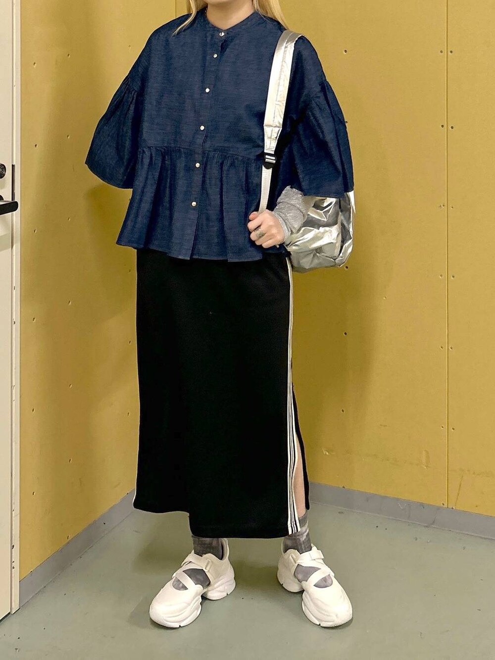 ホワイト系のサンダル、ブラック系のスカート、シルバー系のバックパック/リュックを着用したレディースの春コーディネートの2枚目の写真