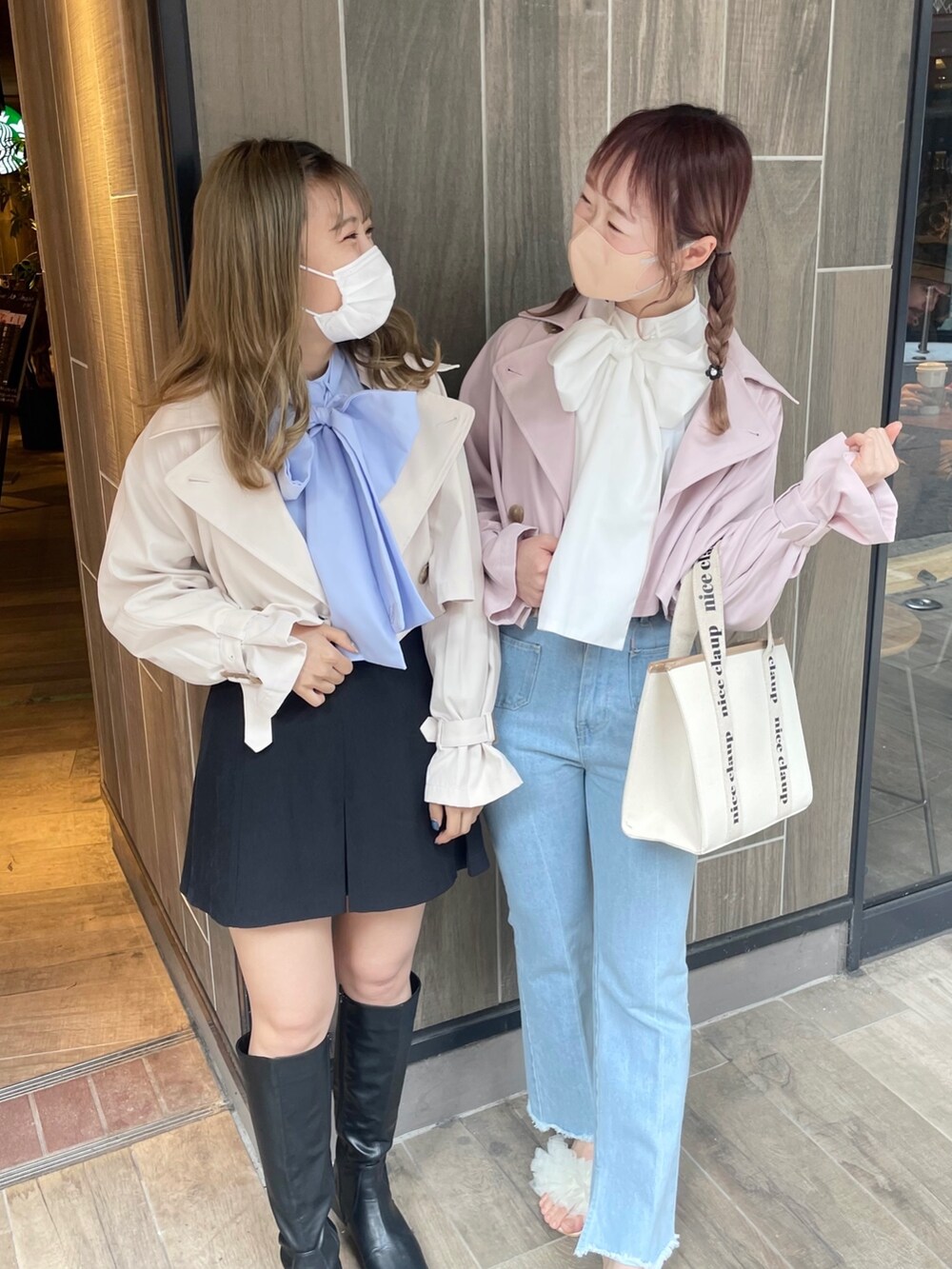 ピンク系のトレンチコート、ブルー系のデニムパンツ、ホワイト系のサンダルを着用したレディースの春コーディネートの2枚目の写真
