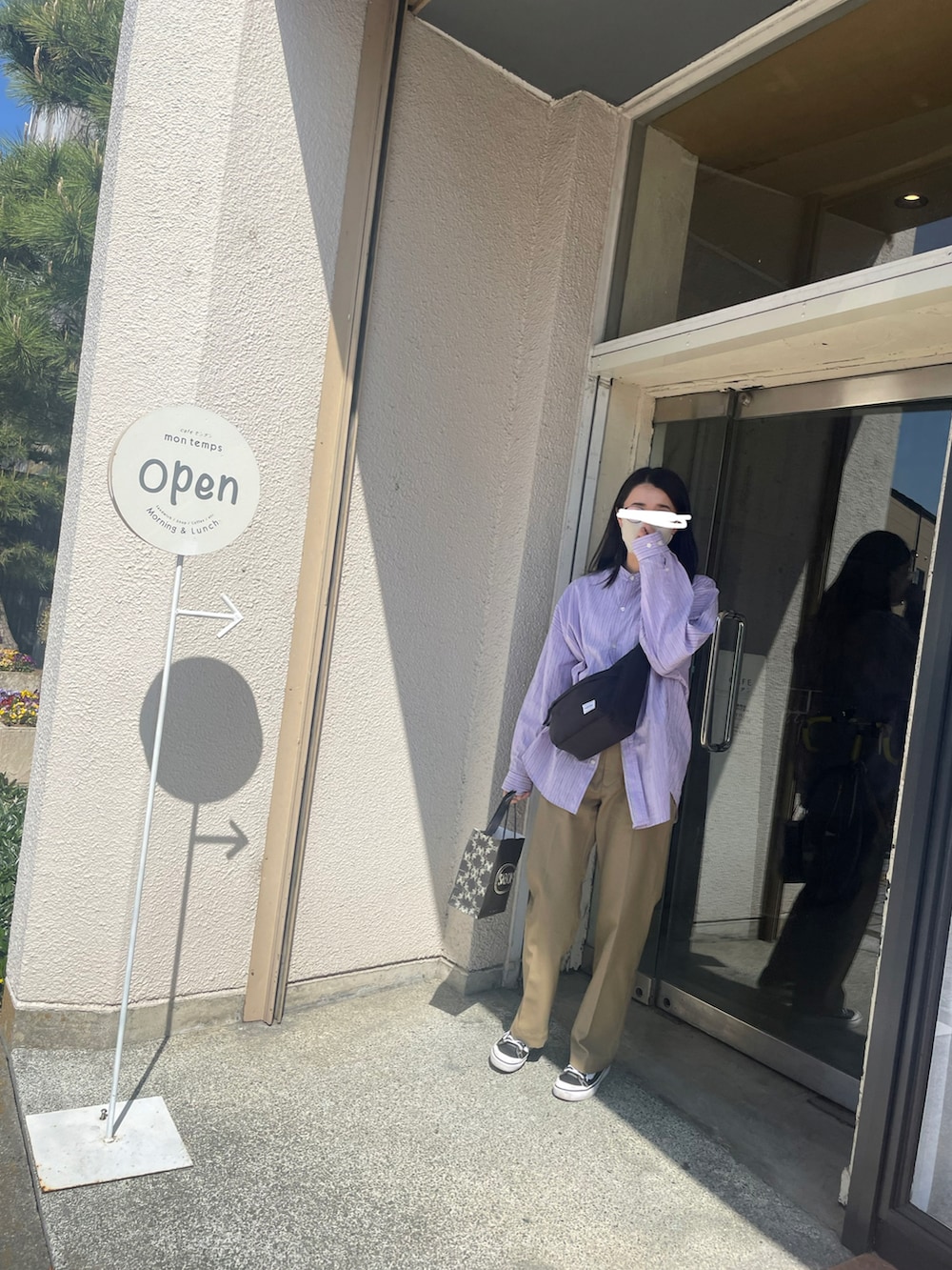 パープル系のシャツ/ブラウス、ブラック系のショルダーバッグ、ベージュ系のチノパンツを着用したレディースの春コーディネートの2枚目の写真