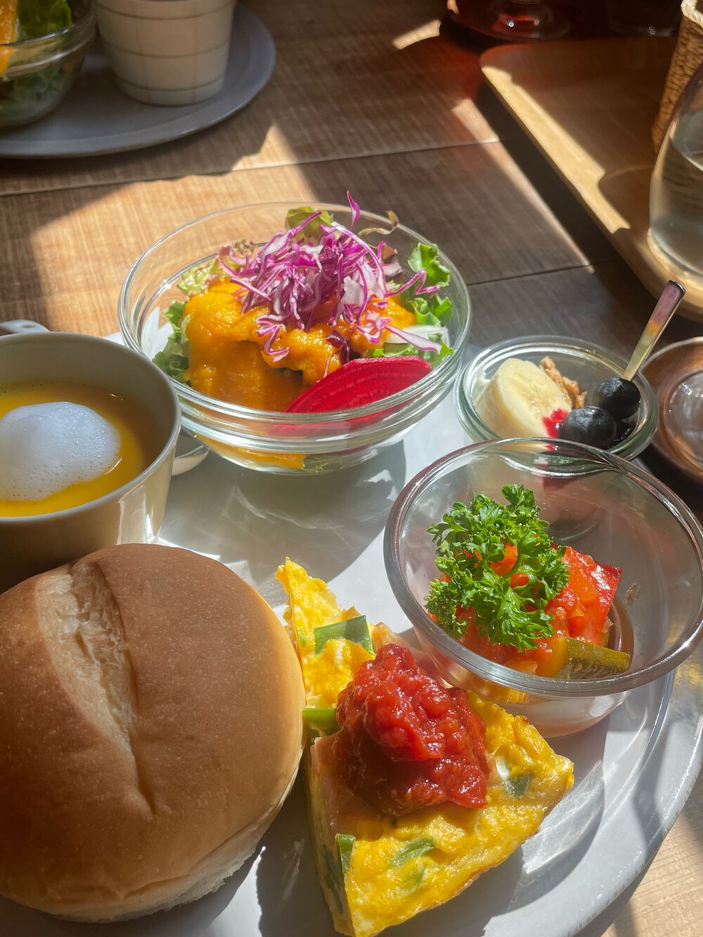 ブラック系のワンピース、ブラック系のサンダル、ホワイト系のショルダーバッグを着用したレディースの夏コーディネートの2枚目の写真