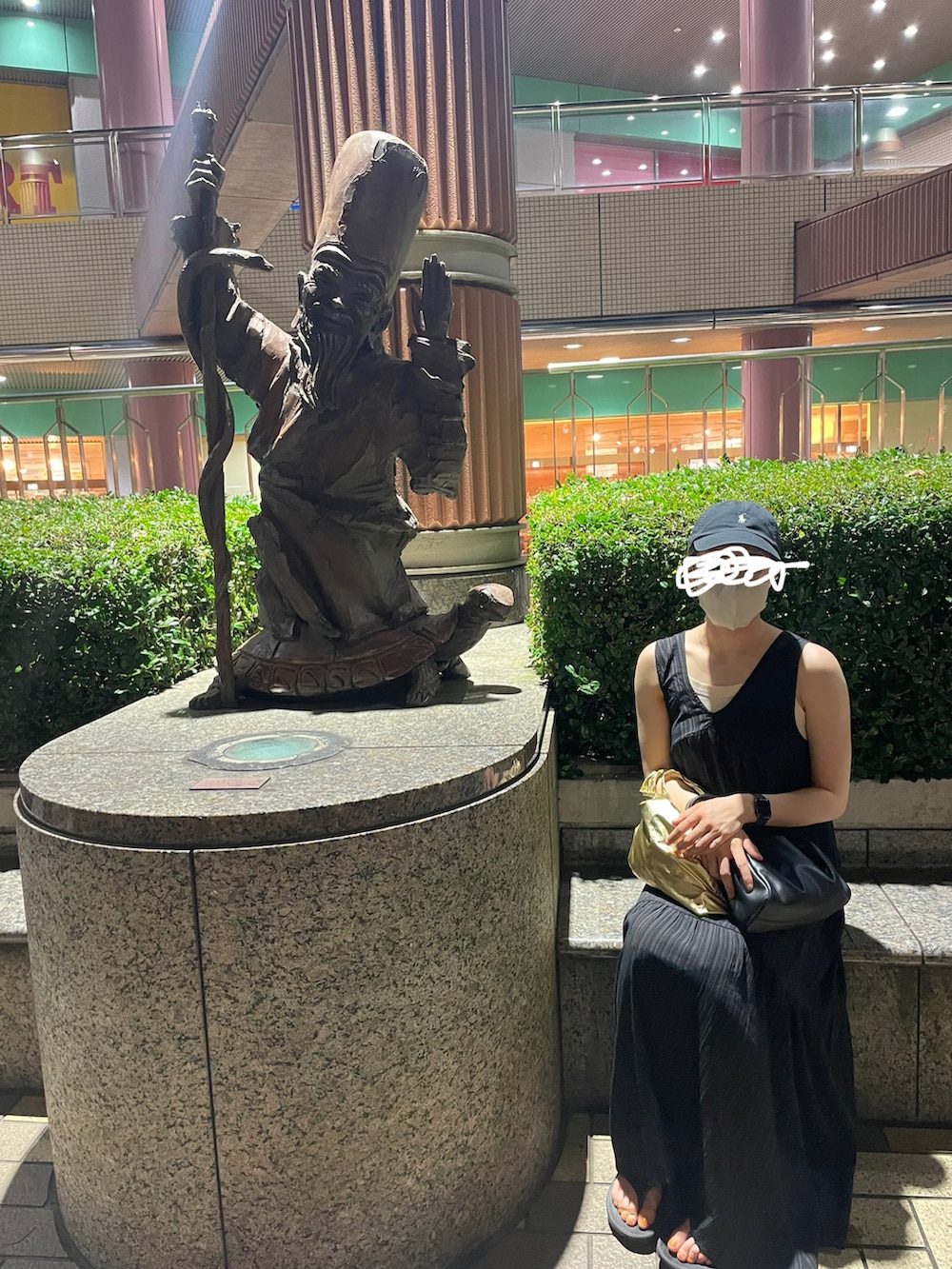 ブラック系のワンピース、ブラック系のサンダル、ブラック系のハンドバッグを着用したレディースの夏コーディネートの3枚目の写真