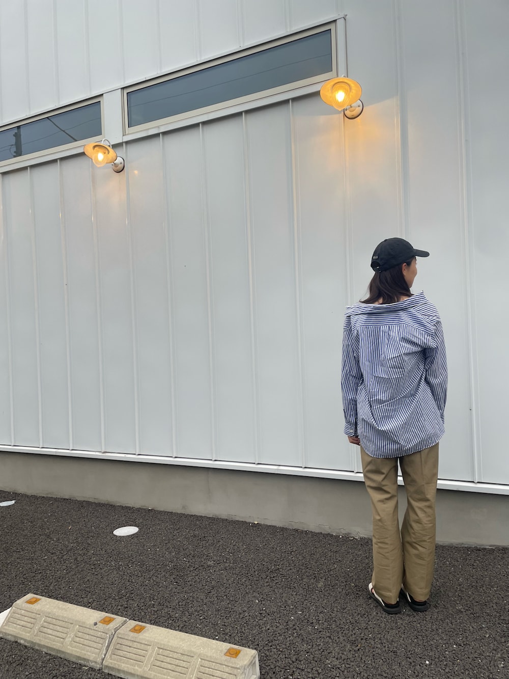 ベージュ系のチノパンツ、ホワイト系のサンダル、ブルー系のシャツ/ブラウスを着用したレディースの春コーディネートの2枚目の写真