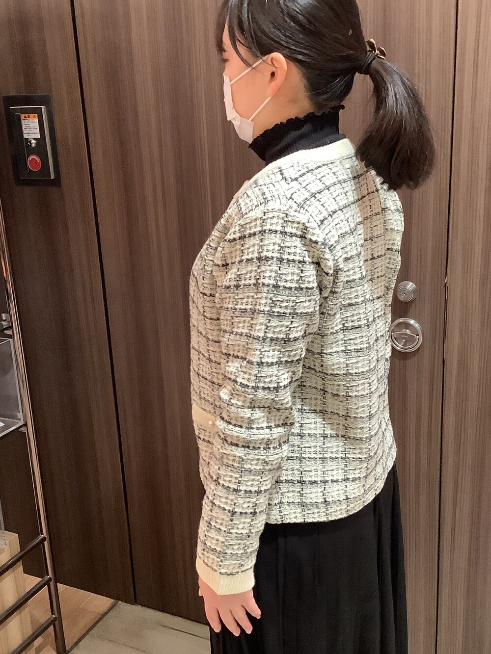 ホワイト系のノーカラージャケットを着用したレディースの冬コーディネートの2枚目の写真