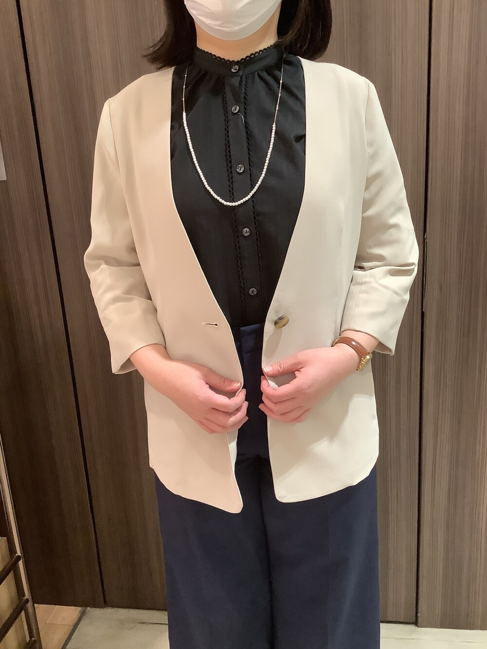 ベージュ系のノーカラージャケット、ブラック系のシャツ/ブラウスを着用したレディースの春コーディネートの2枚目の写真