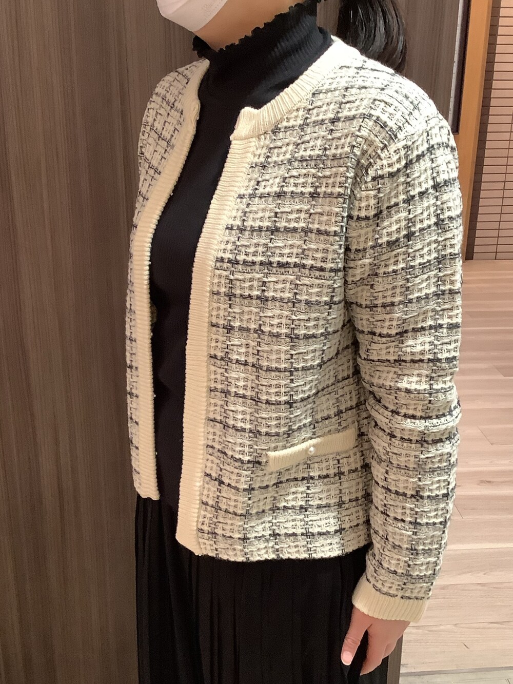 ホワイト系のノーカラージャケットを着用したレディースの冬コーディネートの3枚目の写真