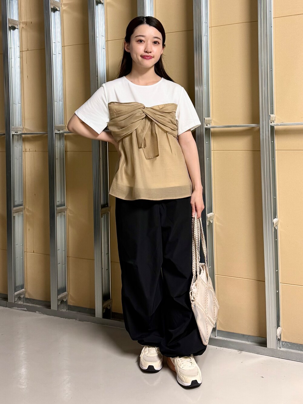 ホワイト系のTシャツ/カットソー、ブラック系のその他パンツ、ベージュ系のトートバッグを着用したレディースの春コーディネートの3枚目の写真