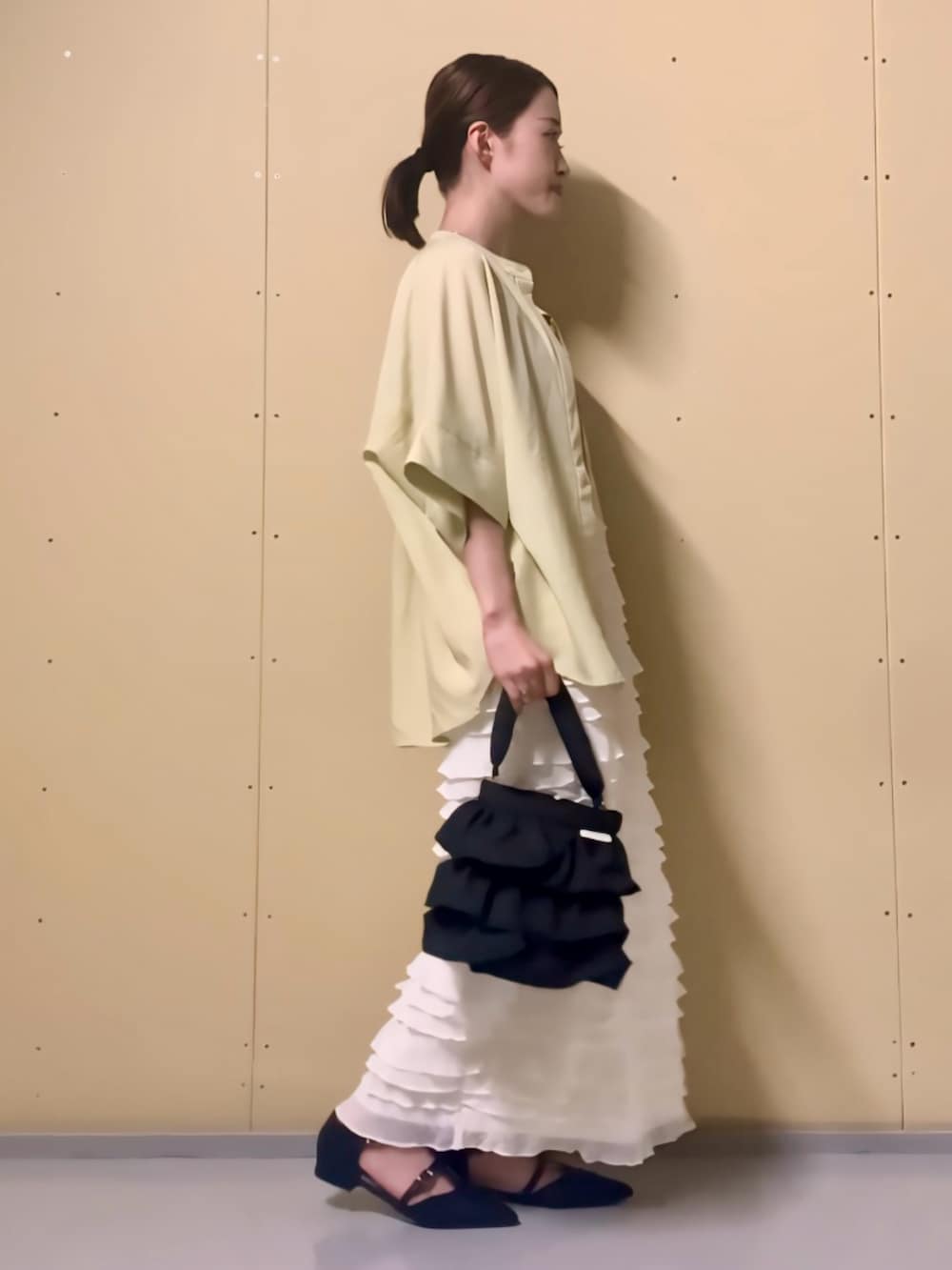 イエロー系のシャツ/ブラウス、ベージュ系のタンクトップ、ホワイト系のスカートを着用したレディースの夏コーディネートの3枚目の写真