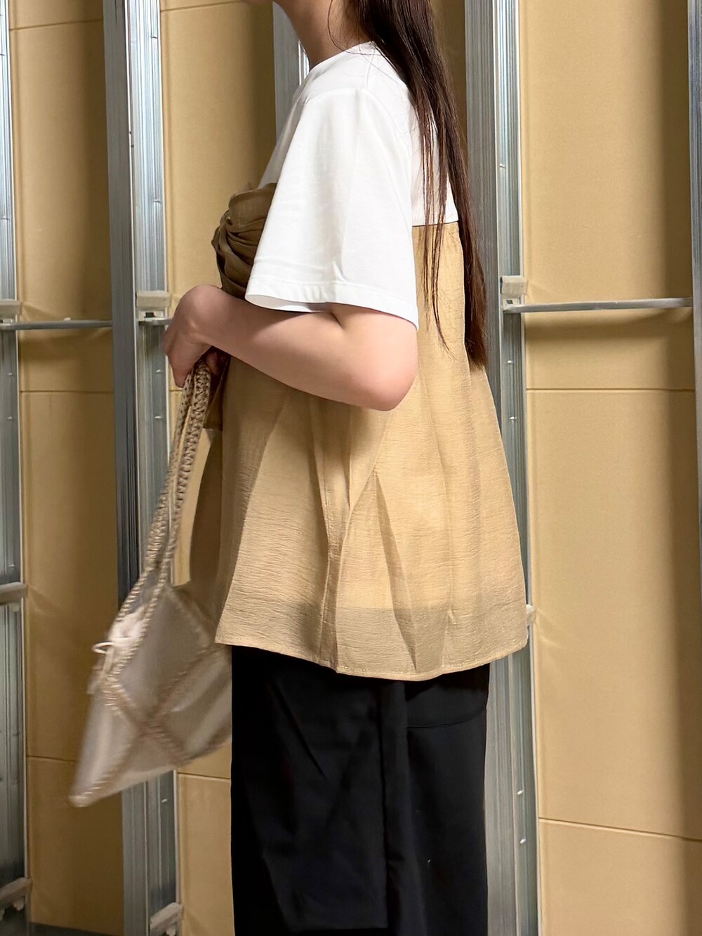 ホワイト系のTシャツ/カットソー、ブラック系のその他パンツ、ベージュ系のトートバッグを着用したレディースの春コーディネートの10枚目の写真