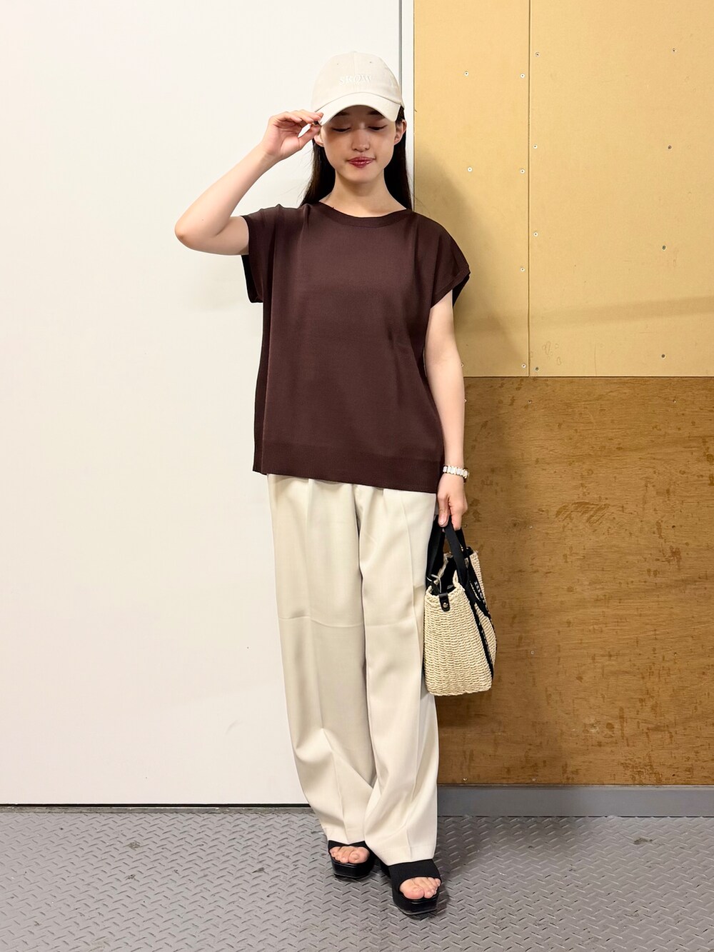 ブラウン系のニット/セーター、ベージュ系のその他パンツ、ベージュ系のハンドバッグを着用したレディースの春コーディネートの2枚目の写真