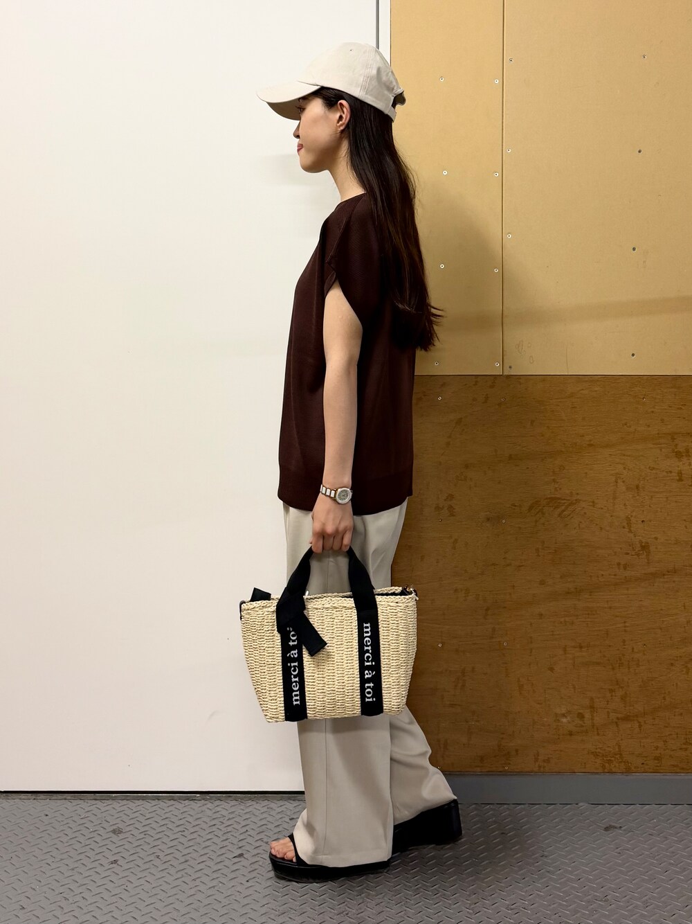 ブラウン系のニット/セーター、ベージュ系のその他パンツ、ベージュ系のハンドバッグを着用したレディースの春コーディネートの6枚目の写真