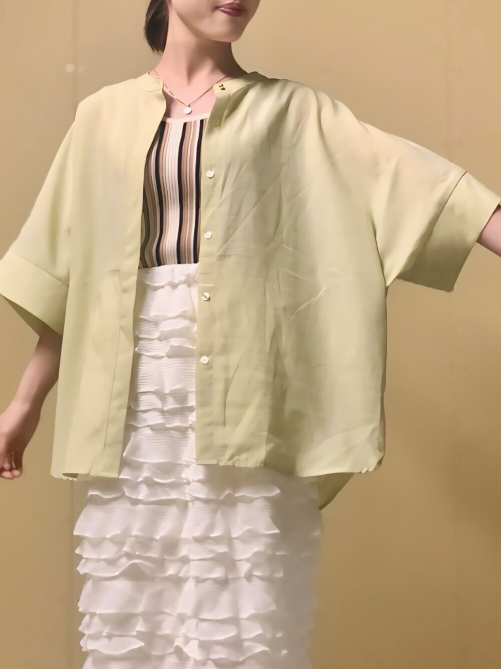イエロー系のシャツ/ブラウス、ベージュ系のタンクトップ、ホワイト系のスカートを着用したレディースの夏コーディネートの5枚目の写真