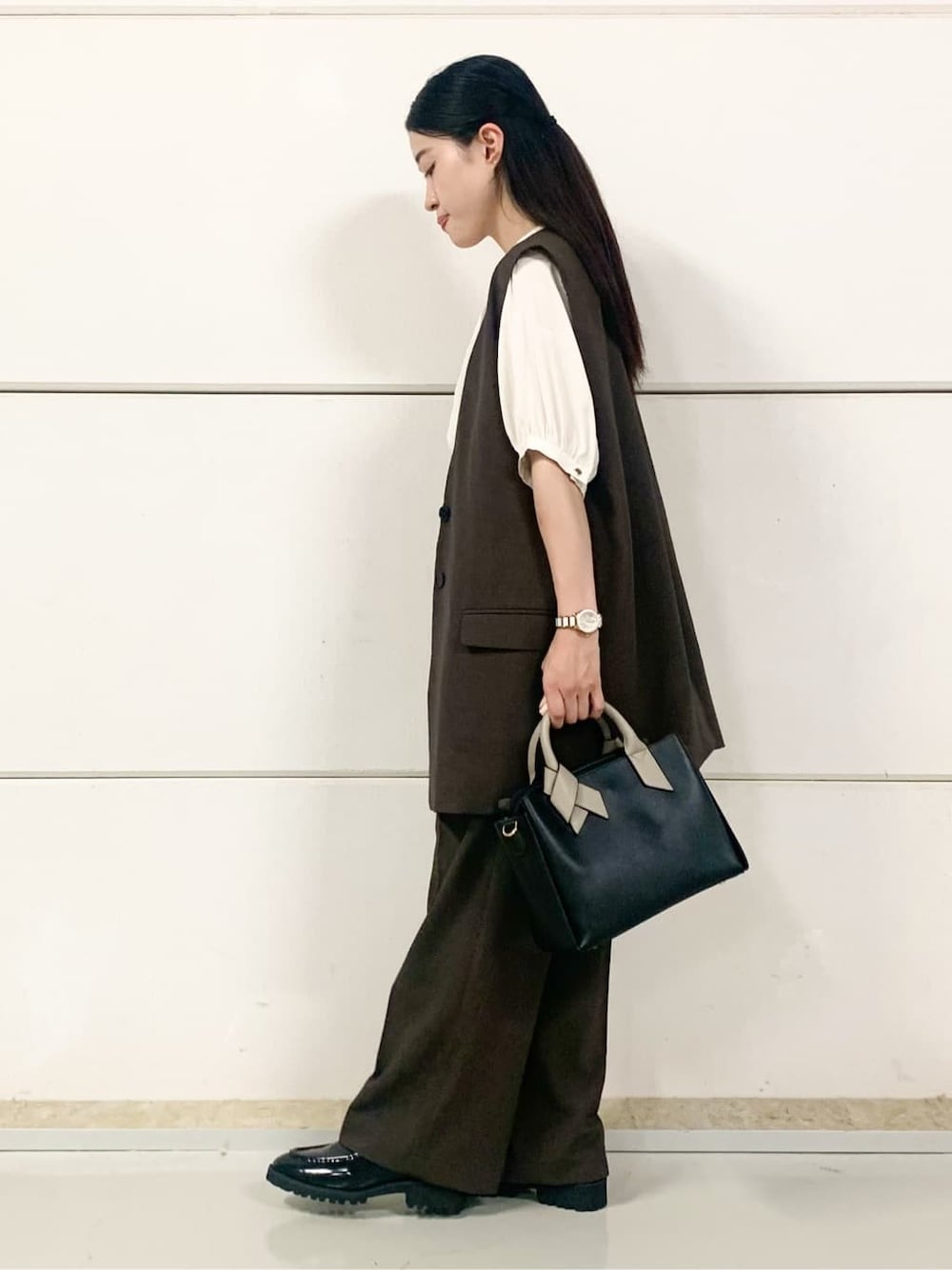 ブラウン系のベスト、ホワイト系のシャツ/ブラウス、ブラウン系のその他パンツを着用したレディースの秋コーディネートの5枚目の写真