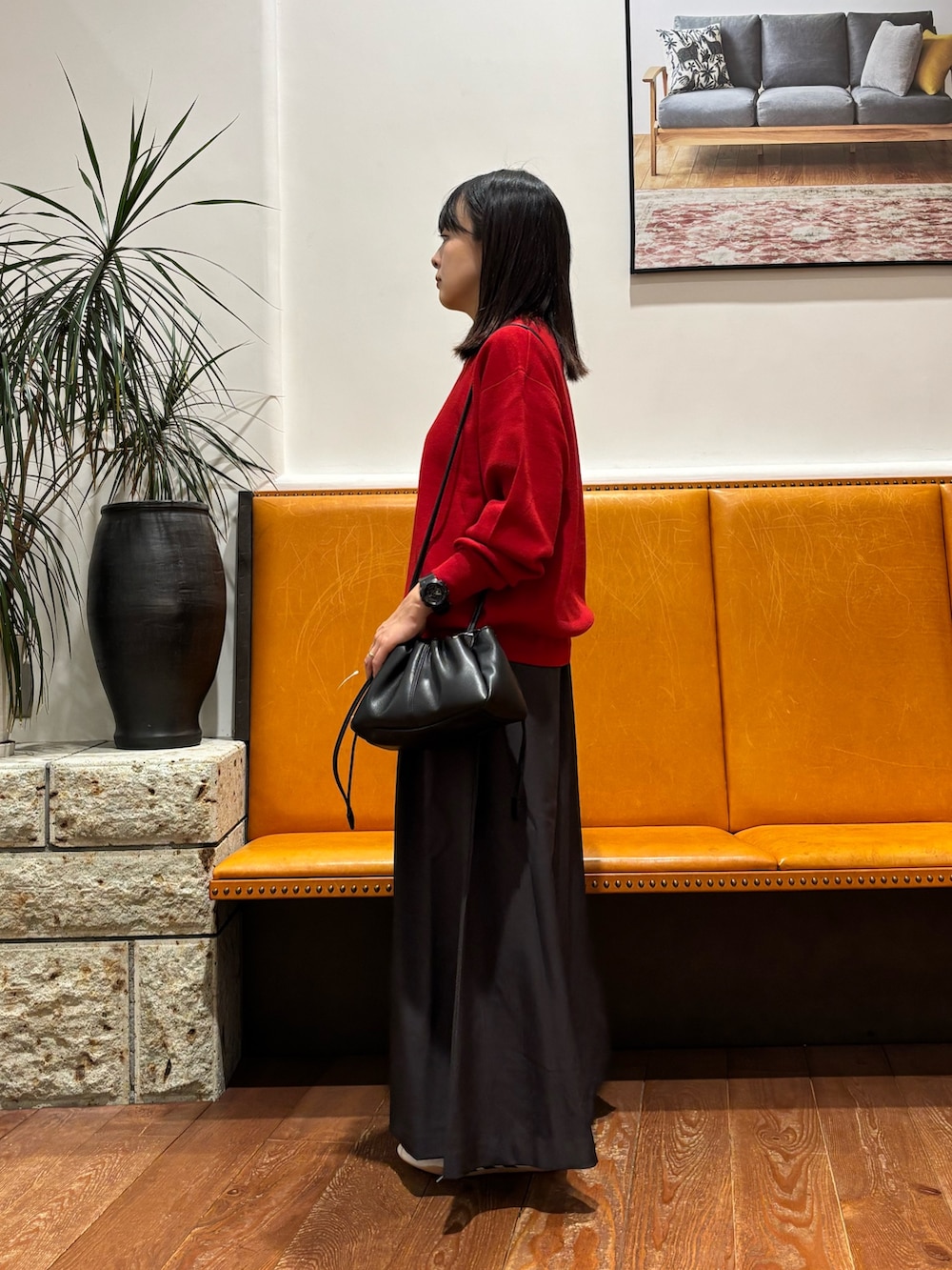 レッド系のニット/セーター、グレー系のスカート、ブラック系のショルダーバッグを着用したレディースの秋コーディネートの2枚目の写真