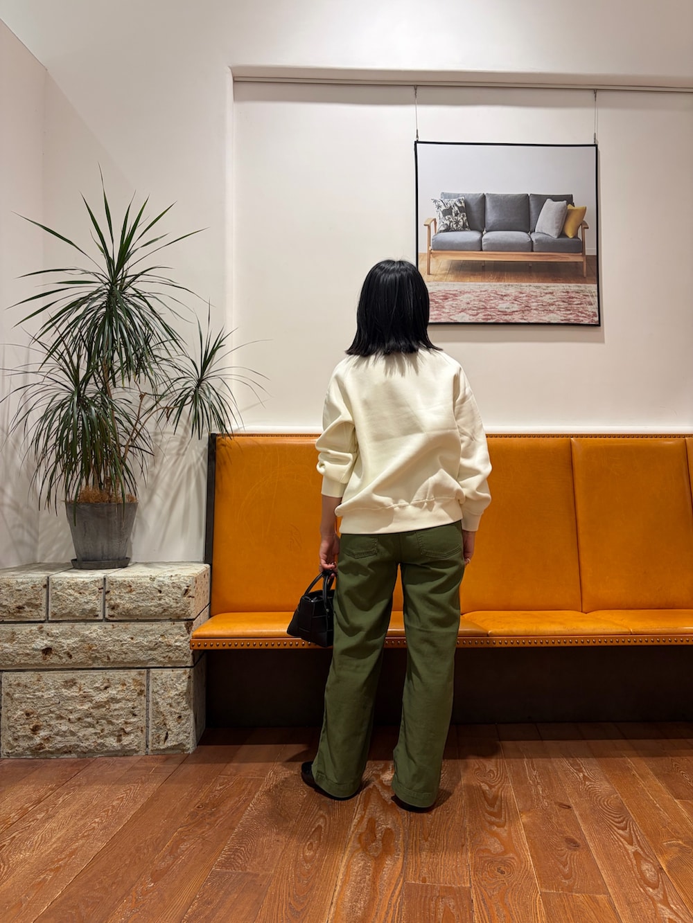 グリーン系のその他パンツ、ホワイト系のスウェット、ブラック系のハンドバッグを着用したレディースの秋コーディネートの2枚目の写真